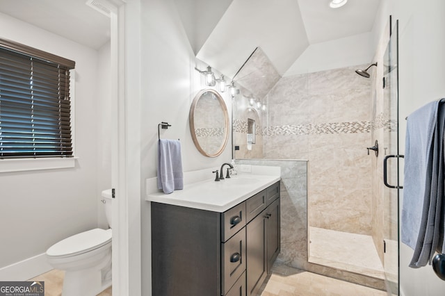 bathroom featuring tile patterned flooring, toilet, vanity, and a tile shower