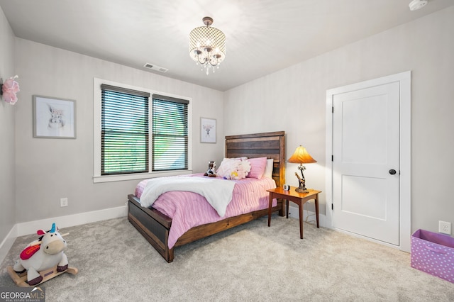 bedroom with a notable chandelier and light colored carpet