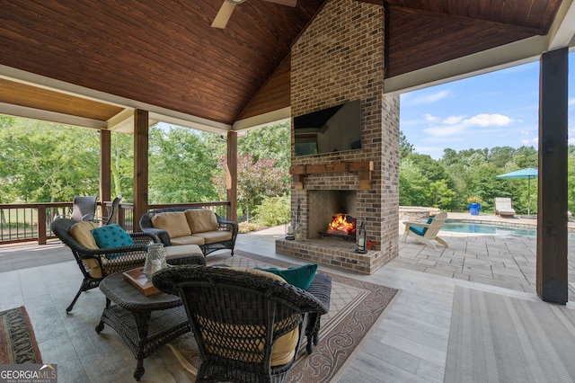 view of patio / terrace with an outdoor living space with a fireplace and ceiling fan