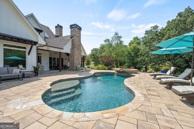 view of pool with a patio area and an in ground hot tub