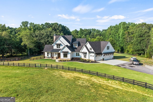 view of front facade featuring a garage, a front lawn, and a rural view