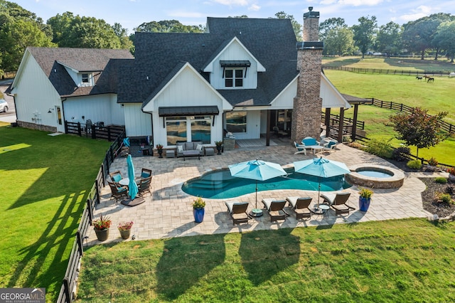 back of house with an outdoor living space, a patio area, a pool with hot tub, and a lawn