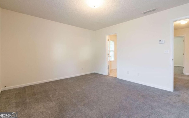 carpeted spare room with a textured ceiling