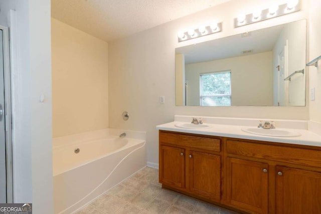 bathroom featuring vanity, a bathtub, and a textured ceiling