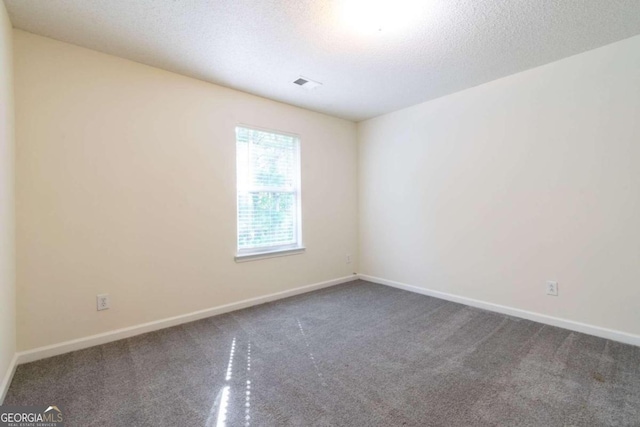 carpeted spare room featuring a textured ceiling