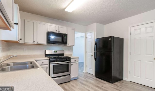 kitchen with tasteful backsplash, black appliances, sink, a textured ceiling, and white cabinets