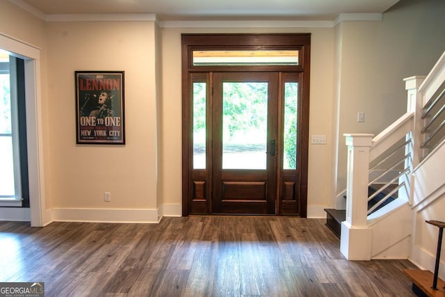 foyer entrance featuring stairs, ornamental molding, and dark wood finished floors