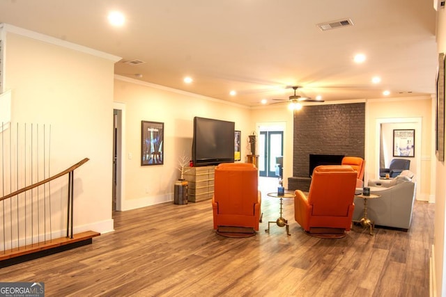 living room with baseboards, a fireplace, visible vents, and wood finished floors