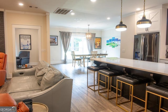 kitchen with stainless steel fridge, visible vents, white cabinetry, and light countertops