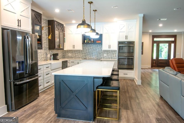 kitchen featuring white cabinets, appliances with stainless steel finishes, light countertops, and glass insert cabinets