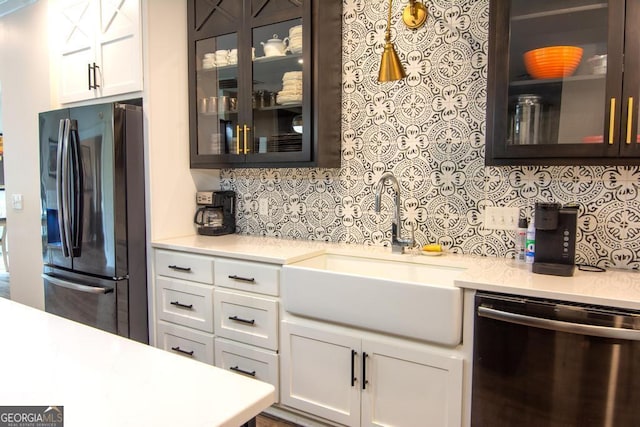 kitchen with stainless steel appliances, glass insert cabinets, a sink, and white cabinetry