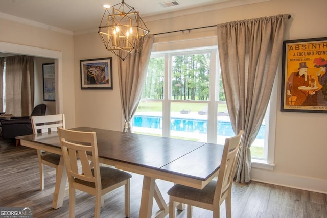 dining space featuring a healthy amount of sunlight, crown molding, baseboards, and wood finished floors