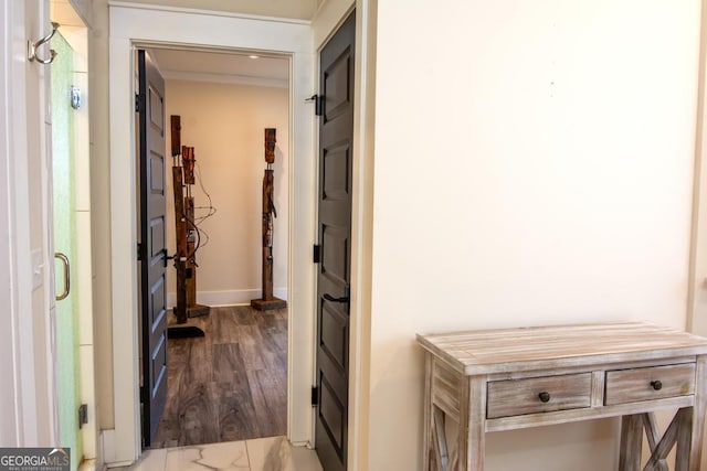 hallway featuring dark wood-style flooring and baseboards