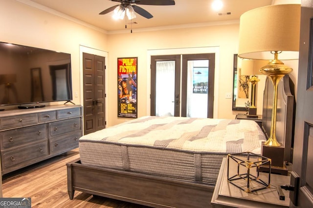 bedroom featuring light wood-style floors, visible vents, crown molding, and french doors