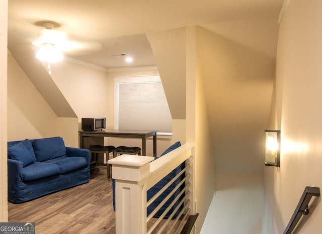 stairs with crown molding and wood finished floors