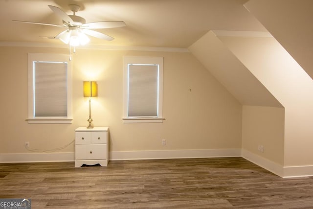 additional living space featuring dark wood-type flooring, lofted ceiling, ceiling fan, and baseboards