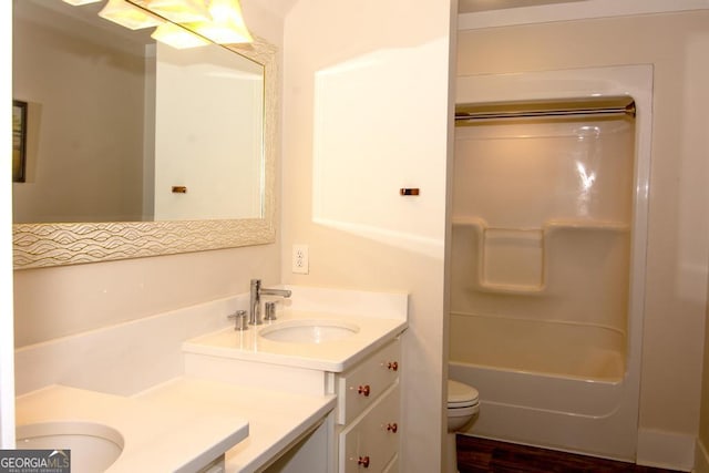 bathroom with toilet, wood finished floors, bathtub / shower combination, and vanity