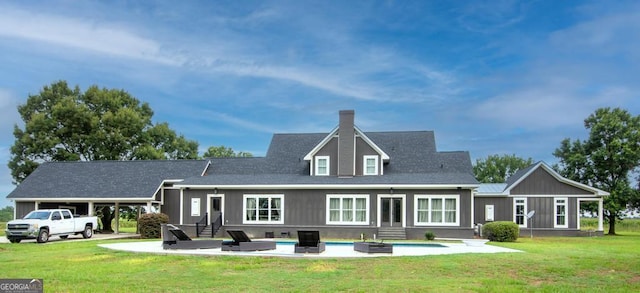 rear view of property featuring entry steps, a carport, and a yard