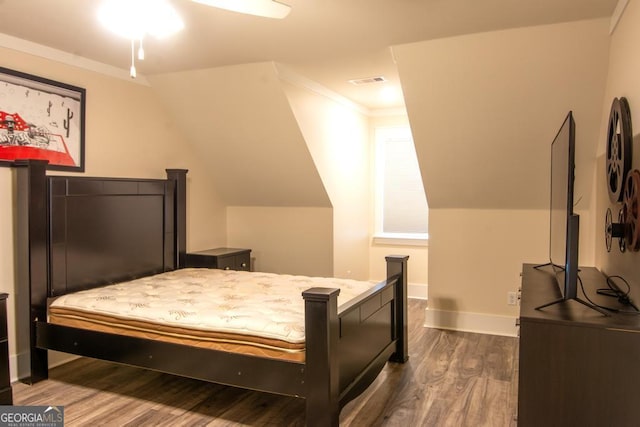 bedroom with dark wood-style flooring, visible vents, baseboards, vaulted ceiling, and ornamental molding