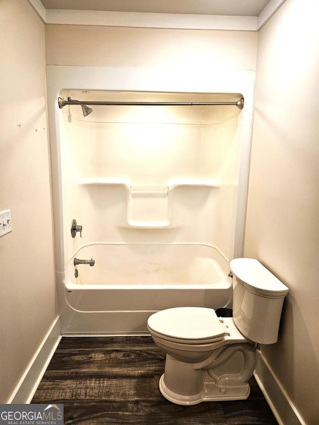 full bathroom with shower / washtub combination, baseboards, toilet, and wood finished floors