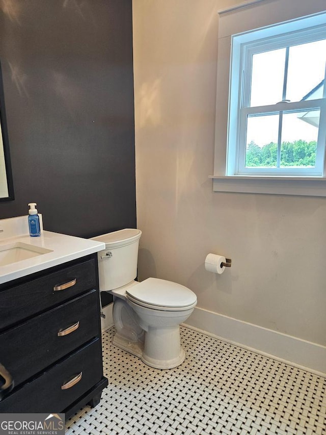 bathroom with tile patterned flooring, toilet, vanity, and baseboards