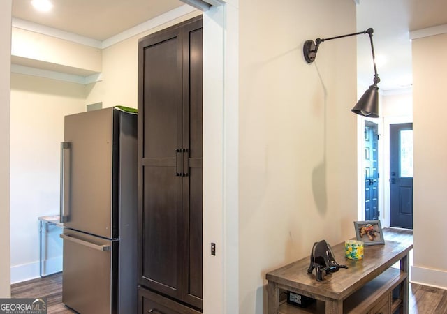 kitchen with baseboards, dark wood finished floors, freestanding refrigerator, dark brown cabinets, and crown molding