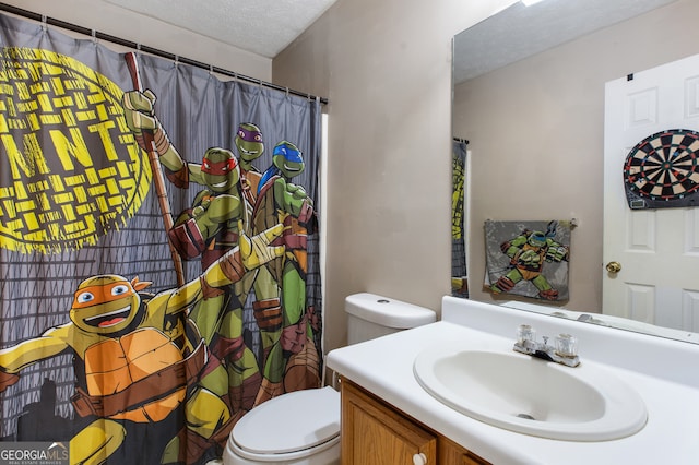 bathroom featuring a textured ceiling, toilet, and vanity