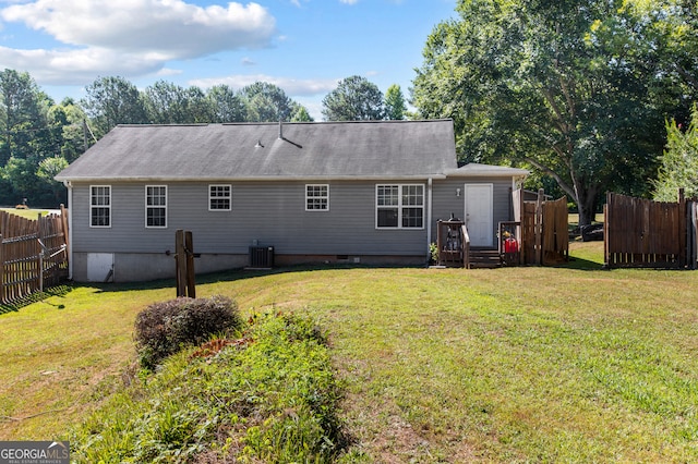 back of house with a wooden deck, central air condition unit, and a lawn