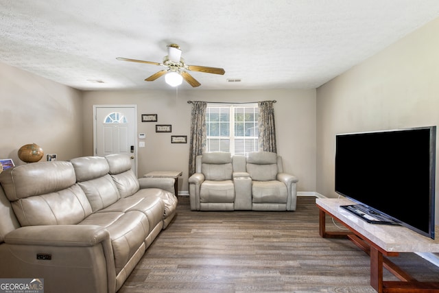 living room with hardwood / wood-style floors, ceiling fan, and a textured ceiling