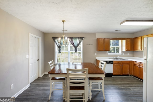 kitchen featuring sink, dark wood-type flooring, white appliances, and a chandelier