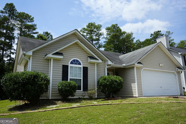 view of front of home with a garage and a front lawn