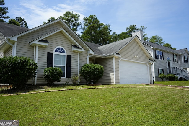 view of front of property with a garage and a front lawn