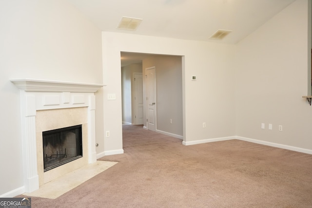 unfurnished living room featuring light carpet and a tile fireplace