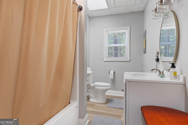 full bathroom featuring toilet, a paneled ceiling, shower / tub combo, wood-type flooring, and vanity