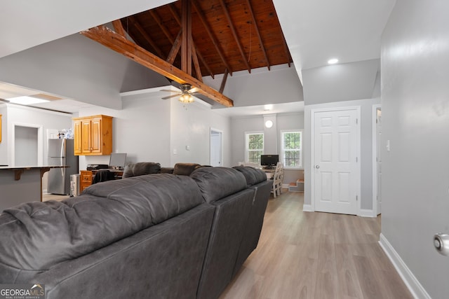 living room with high vaulted ceiling, wooden ceiling, light wood-type flooring, and beamed ceiling