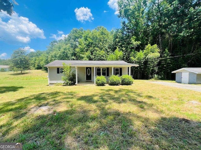 ranch-style home featuring a garage, an outbuilding, and a front lawn