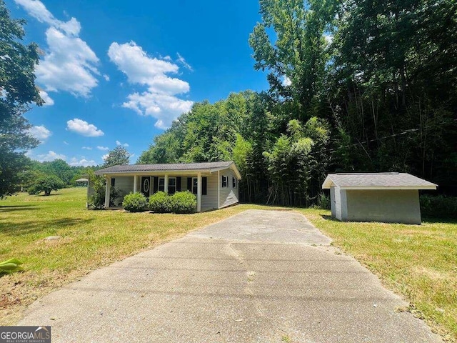 single story home featuring an outdoor structure and a front lawn