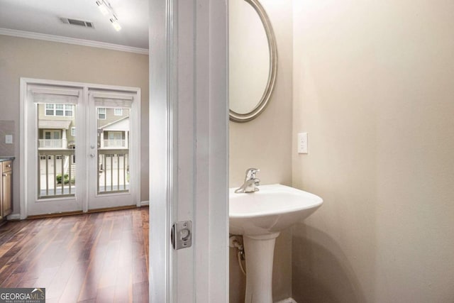 bathroom featuring crown molding, hardwood / wood-style floors, and sink