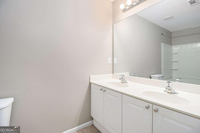 bathroom with tile patterned flooring, vanity, and toilet