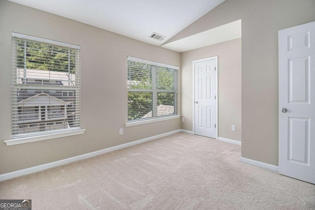 unfurnished bedroom with light carpet and vaulted ceiling