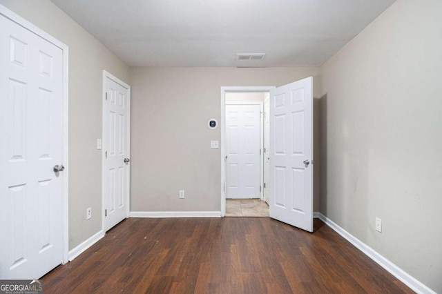 unfurnished bedroom featuring dark hardwood / wood-style flooring