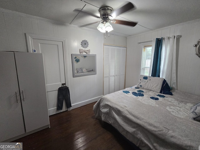 bedroom featuring a textured ceiling, ceiling fan, dark wood-type flooring, and a closet