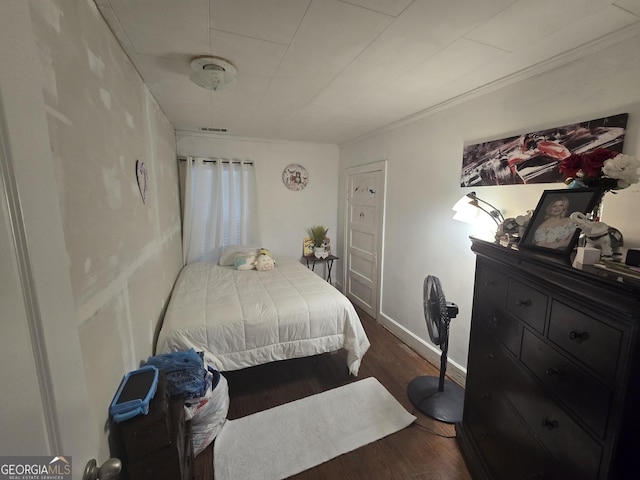 bedroom featuring dark hardwood / wood-style floors and crown molding