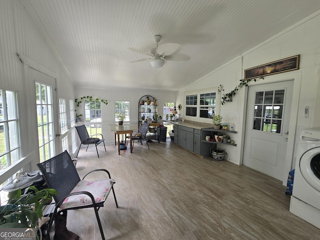 sunroom / solarium featuring washer / clothes dryer, ceiling fan, french doors, and lofted ceiling