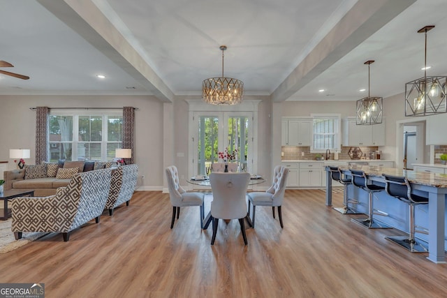 dining space with light hardwood / wood-style flooring, ornamental molding, and sink