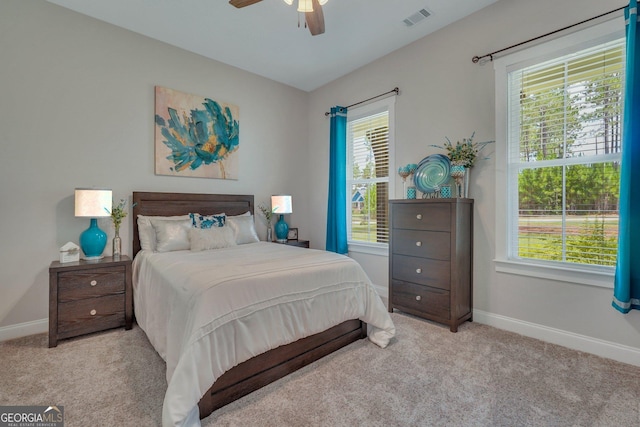 carpeted bedroom featuring ceiling fan and multiple windows