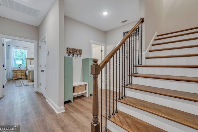 staircase with hardwood / wood-style floors