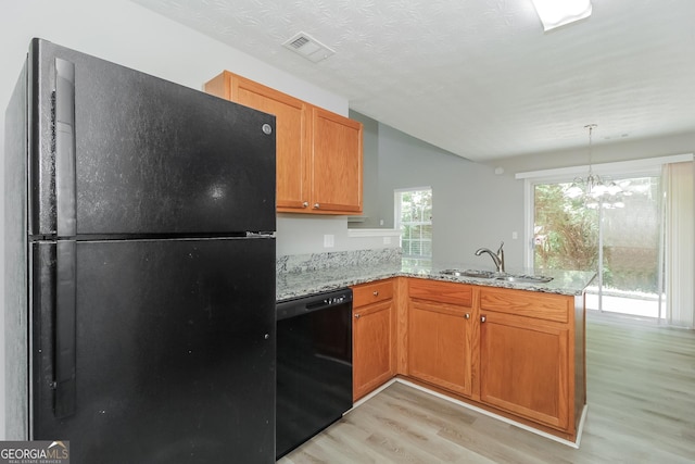 kitchen with black appliances, an inviting chandelier, light hardwood / wood-style floors, sink, and kitchen peninsula