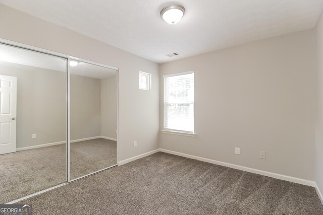 unfurnished bedroom featuring carpet and a closet