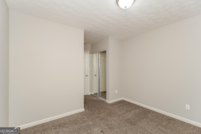 carpeted spare room featuring a textured ceiling